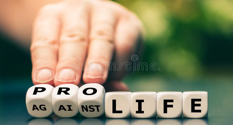 Hand turns dice and changes the expression `against life` to `pro life. Hand turns dice and changes the expression `against life` to `pro life