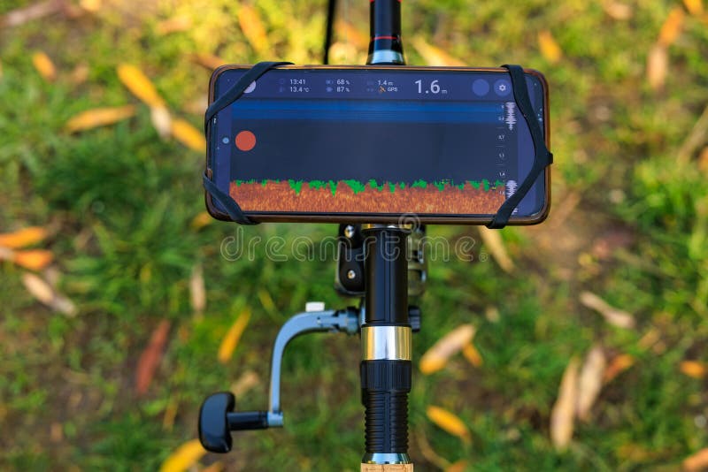 手机安装在鱼竿支架上，实时声纳显示 库存图片
