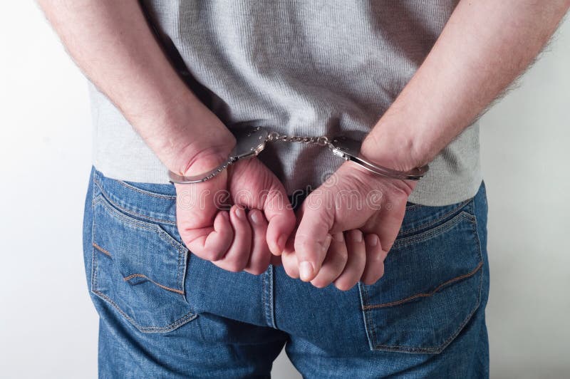 Man hands in handcuffs on a white background. Man hands in handcuffs on a white background