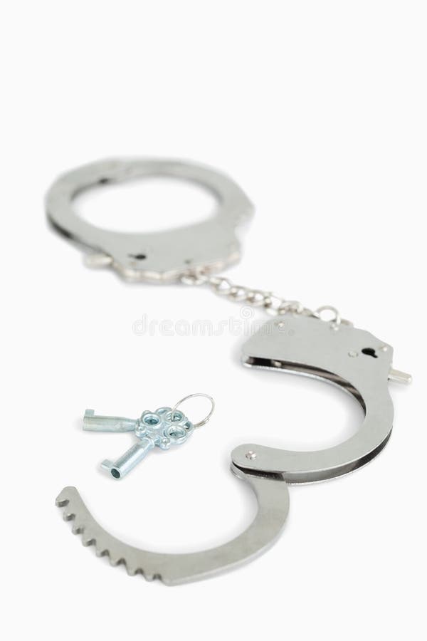Handcuffs and keys against a white background. Handcuffs and keys against a white background