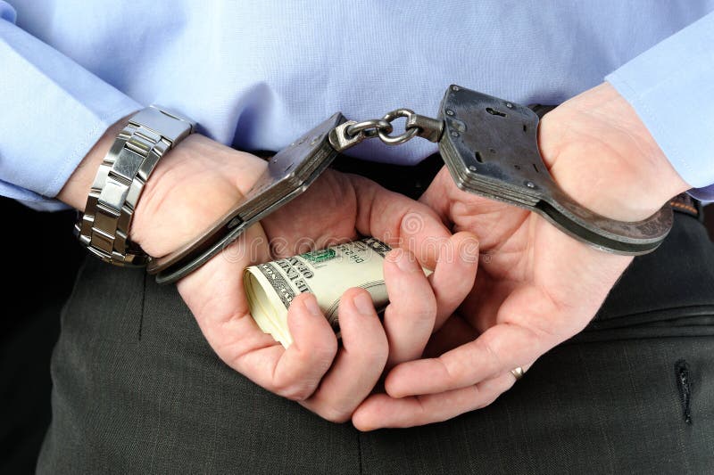 Man in handcuffs holds banknotes in his palms behind his back. Man in handcuffs holds banknotes in his palms behind his back