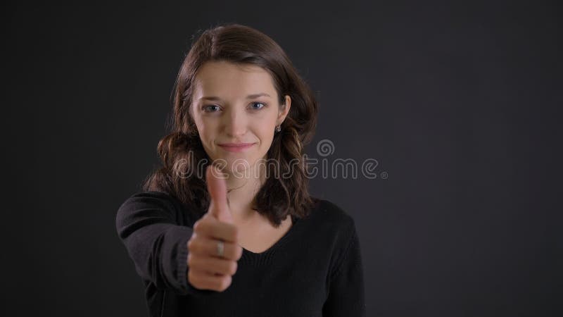 打手势手指在黑背景的逗人喜爱的年轻深色的妇女画象标志微笑地显示象和尊敬 免版税库存照片 打手势手指在黑背景的逗人喜爱的年轻深色的妇女画象标志微笑地显示象和尊敬 免版税库存照片