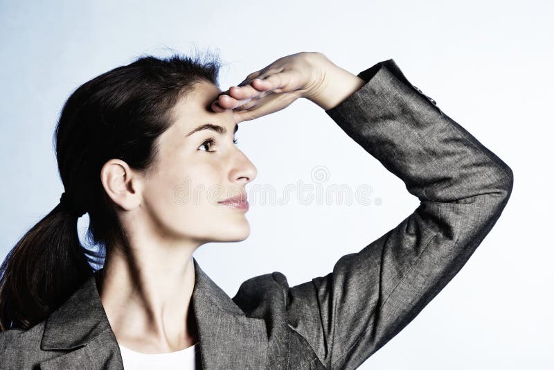 Concept: Positive business outlook. Young businesswoman looking far ahead, on light-blue background. Concept: Positive business outlook. Young businesswoman looking far ahead, on light-blue background.