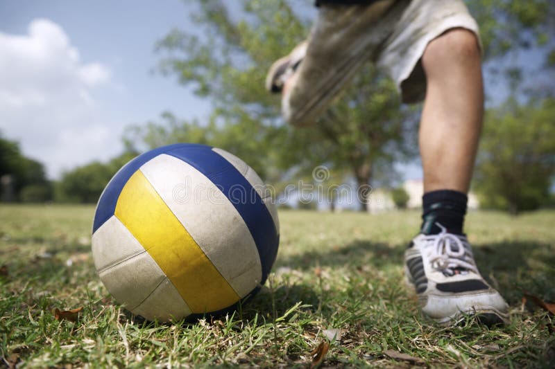 Kids playing football game, young child hitting soccer ball in park. Kids playing football game, young child hitting soccer ball in park