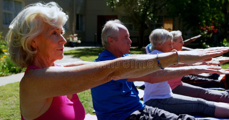 执行瑜伽的活跃mixed-race资深人民侧视图在老人院4k庭院