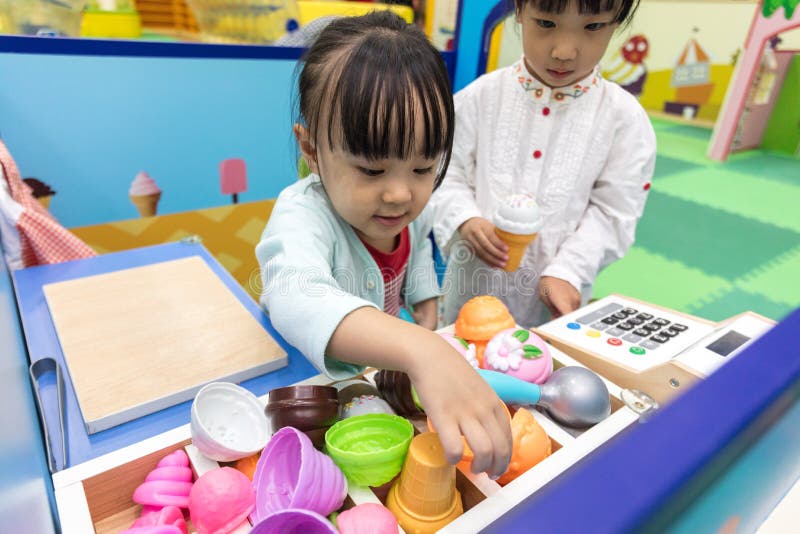 扮演在冰淇凌店的亚裔中国小女孩 库存图片