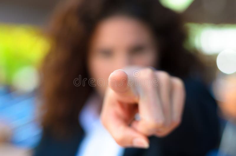 Woman pointing an accusatory finger at the camera with selective focus to the tip of the finger. Woman pointing an accusatory finger at the camera with selective focus to the tip of the finger