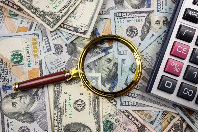 Magnifying glass with calculator over US dollar bill. Finance and business, investment. Magnifying glass with calculator over US dollar bill. Finance and business, investment