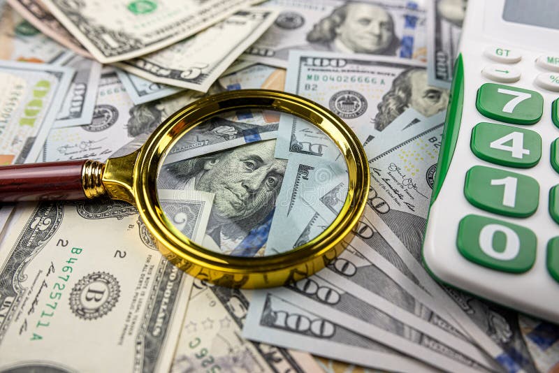 Magnifying glass with calculator over US dollar bill. Finance and business, investment. Magnifying glass with calculator over US dollar bill. Finance and business, investment