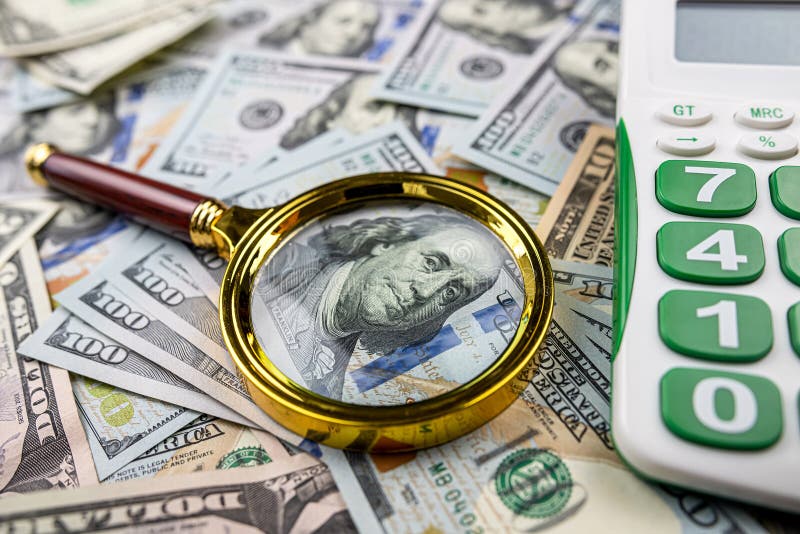 Magnifying glass with calculator over US dollar bill. Finance and business, investment. Magnifying glass with calculator over US dollar bill. Finance and business, investment