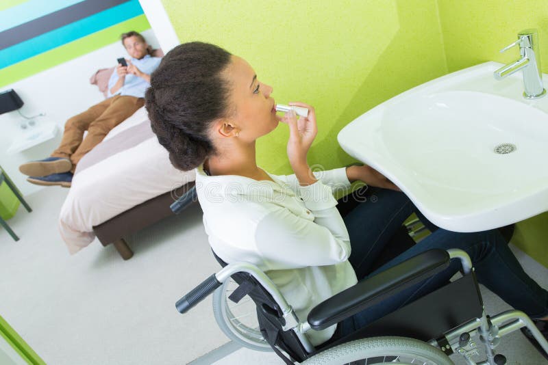 残疾女性在酒店房间里化妆 库存图片