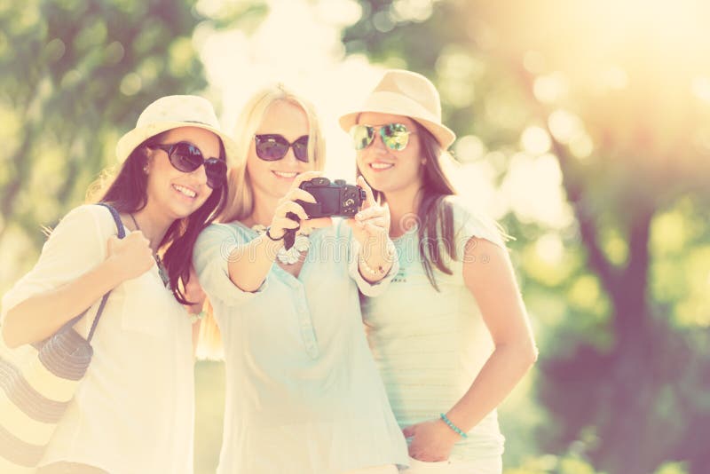 拍照片的三个可爱的女孩暑假
