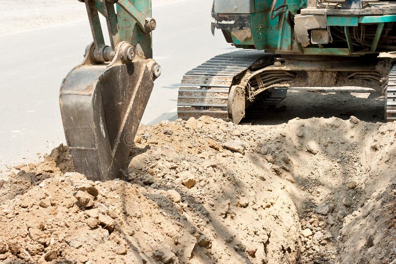 Tractor excavating soil trench for lay pipes. Tractor excavating soil trench for lay pipes