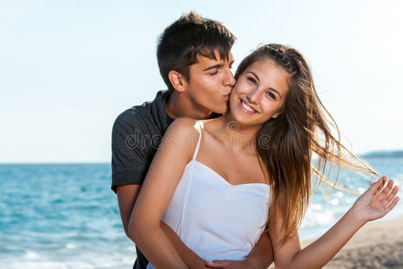 Close up portrait of teen couple embracing on beach. Close up portrait of teen couple embracing on beach.