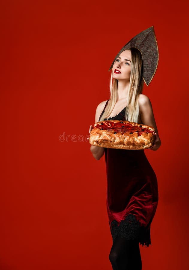 拿着一个可口自创樱桃饼的一个年轻美丽的金发碧眼的女人的画象 免版税图库摄影 拿着一个可口自创樱桃饼的一个年轻美丽的金发碧眼的女人的画象 免版税图库摄影