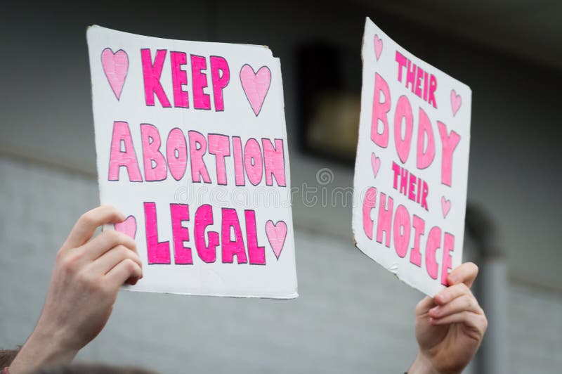 Person holding two pro-choice signs overhead during a pro choice Planned Parenthood demonstration. Person holding two pro-choice signs overhead during a pro choice Planned Parenthood demonstration