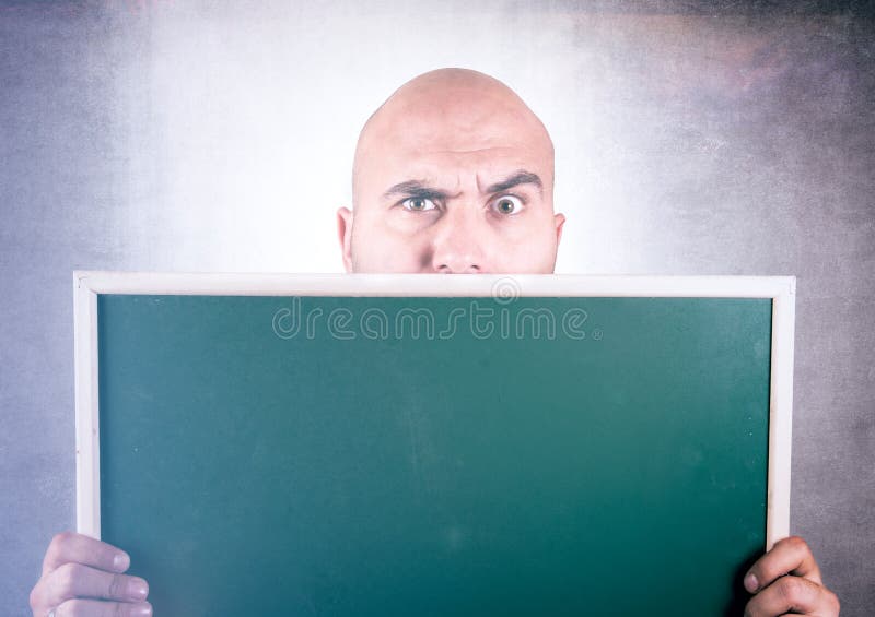 Bold man holding blank chalk board in his hands. Bold man holding blank chalk board in his hands