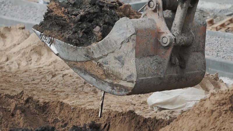 挖掘机桶开掘的土壤沙子和土孔在建筑工地 慢动作