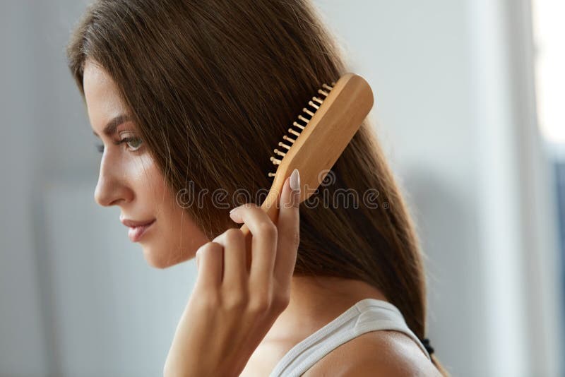 掠过有刷子画象的妇女美丽的健康长的头发 免版税库存图片