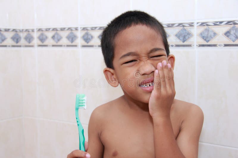 Boy reluctant to brush teeth becauce he is having a toothache. Boy reluctant to brush teeth becauce he is having a toothache.