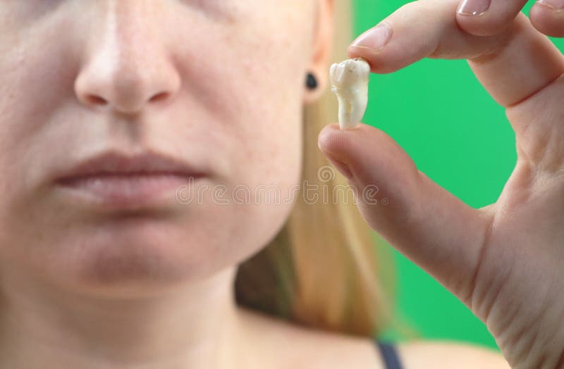 握被拔的牙,在手上的hocus的一名妇女和手的模糊的姿势有牙痛的 免版税库存照片 握被拔的牙,在手上的hocus的一名妇女和手的模糊的姿势有牙痛的 免版税库存照片