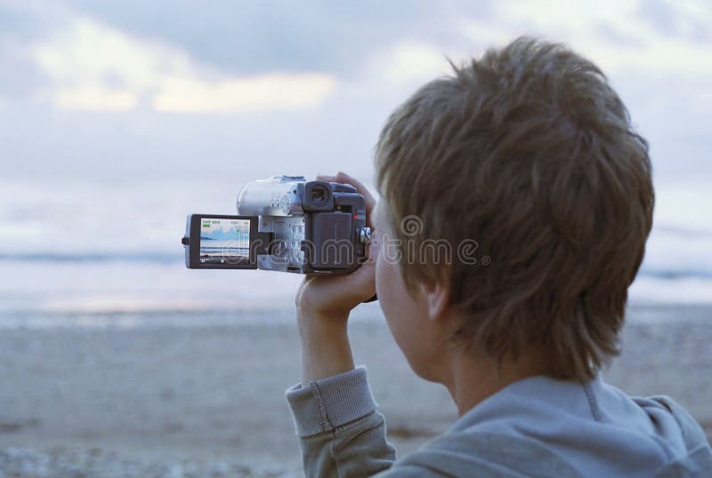 Woman shooting by camcorder on a beach. Woman shooting by camcorder on a beach