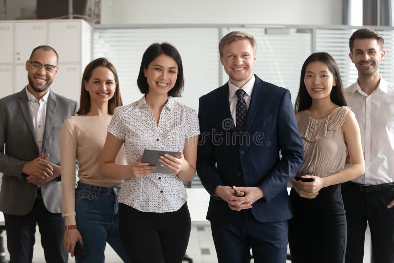 摆在与多文化工作者的不同的专业商业领袖在办公室 免版税图库摄影