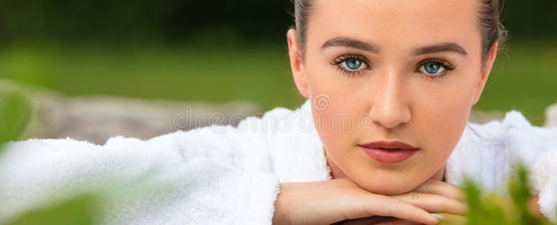 Panoramic web banner of beautiful girl or young woman relaxing in robe outside at health spa. Panoramic web banner of beautiful girl or young woman relaxing in robe outside at health spa