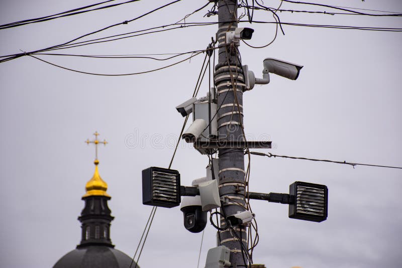 教众和人们追踪神教教堂的概念照片. 在灯杆上安装了许多街道监控摄像头 免版税库存图片