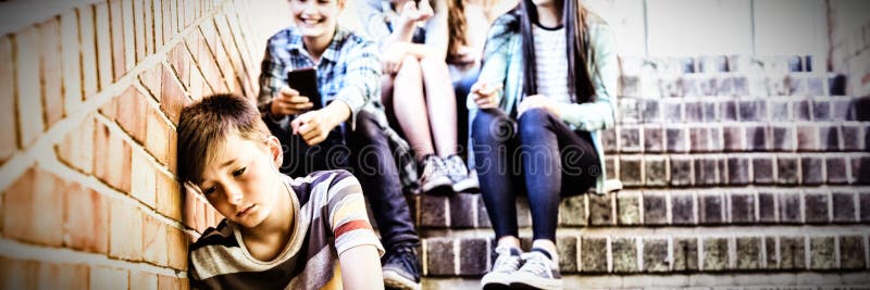 教育脅迫一個哀傷的男孩的朋友在學校走廊 免版稅庫存圖片 教育脅迫一個哀傷的男孩的朋友在學校走廊 免版稅庫存圖片