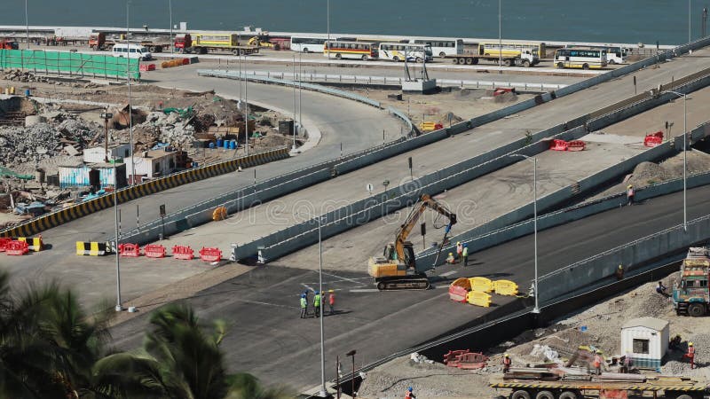 新公路正在建设中. 工人安装路障. 新沥青铺筑路. 男人