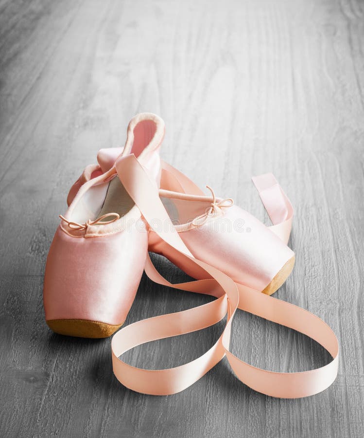 New pink ballet pointe shoes on vintage wooden background. New pink ballet pointe shoes on vintage wooden background