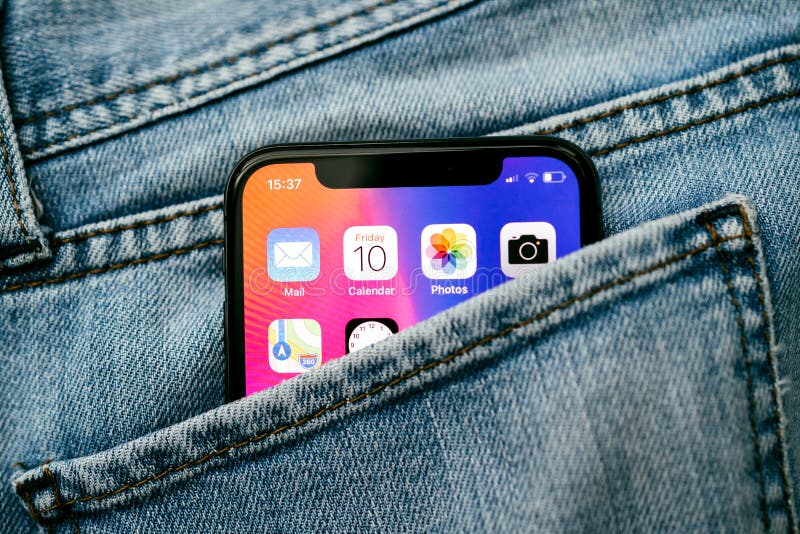 PARIS, FRANCE - NOV 10, 2017: New Apple iPhone X smartphone telephone mobile in pocket of fashion denim jeans pants trousers with home screen apps. PARIS, FRANCE - NOV 10, 2017: New Apple iPhone X smartphone telephone mobile in pocket of fashion denim jeans pants trousers with home screen apps