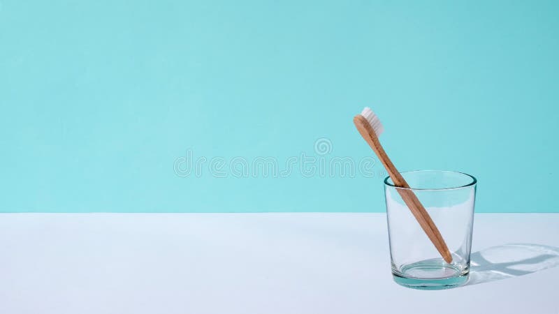 无生态零浪费和自我护理的最小趋势概念. 玻璃杯中的木制牙刷在桌子上移动. 股票录像