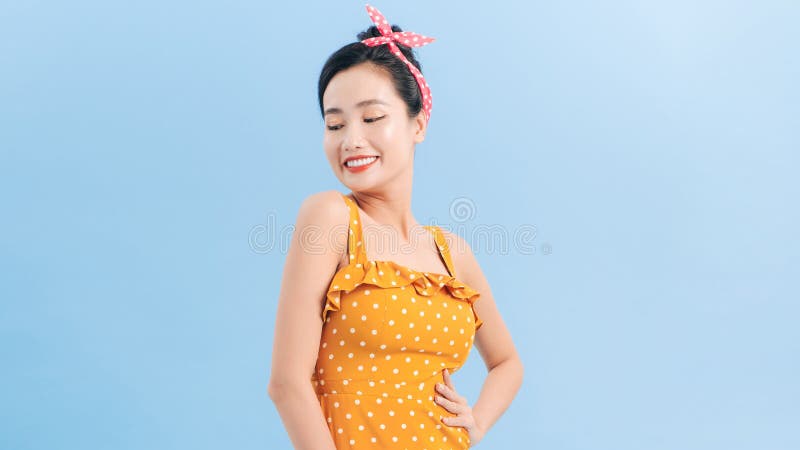 无袖黄色圆点圆点裙的亚洲女性 免版税库存图片