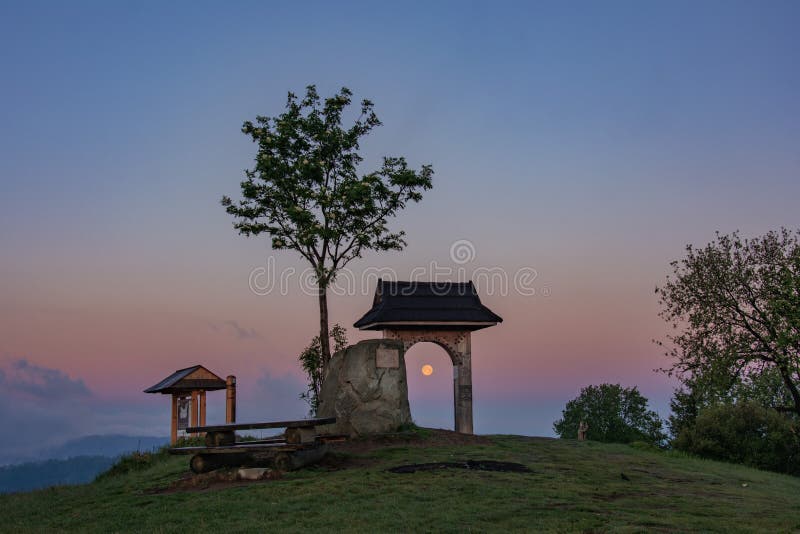 The moon is trapped in some kind of an arc. The scene took place in mountains during sunrise. The sun was rising up in a opposite side of the mountain, so the moon turned out to be yellow-red shaded. The moon is trapped in some kind of an arc. The scene took place in mountains during sunrise. The sun was rising up in a opposite side of the mountain, so the moon turned out to be yellow-red shaded.