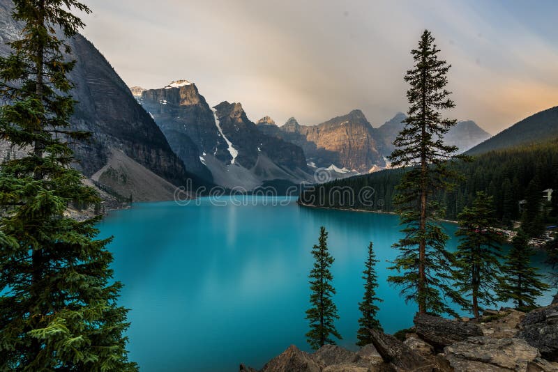 Sunrise with turquoise waters of the Moraine lake with sin lit rocky mountains in Banff National Park of Canada in Valley of the ten peaks. Photo taken in Canada. Sunrise with turquoise waters of the Moraine lake with sin lit rocky mountains in Banff National Park of Canada in Valley of the ten peaks. Photo taken in Canada.