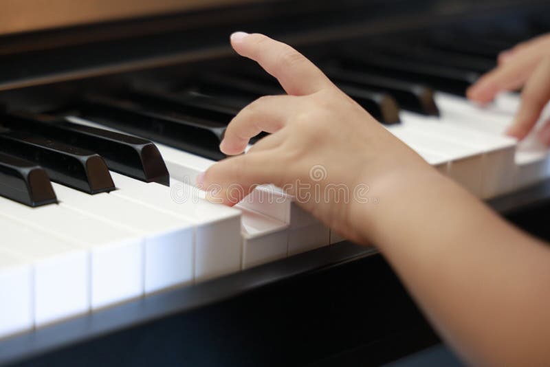 日本女孩弹钢琴的手 免版税库存图片