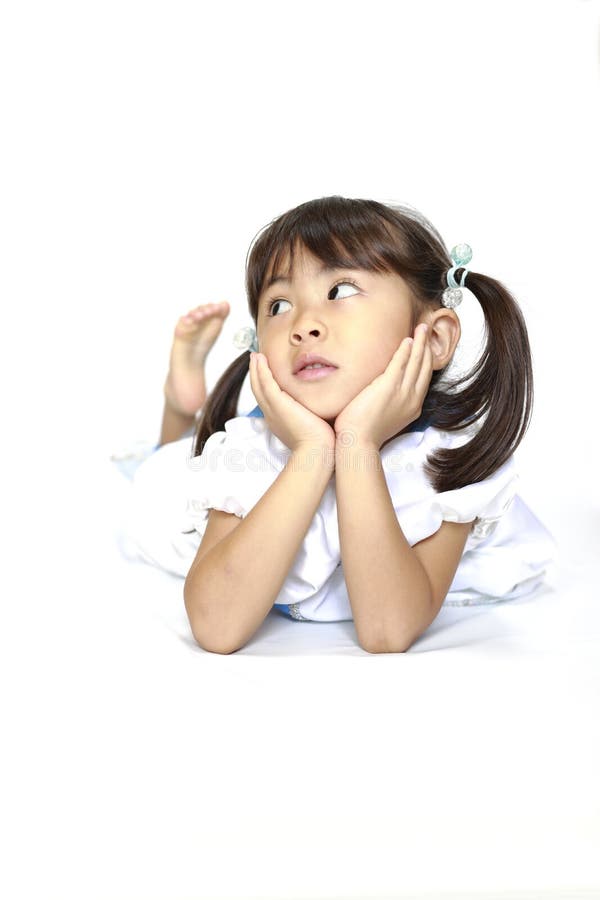 穿着连衣裙的日本女孩，斜躺着，用手托着下巴 免版税库存图片