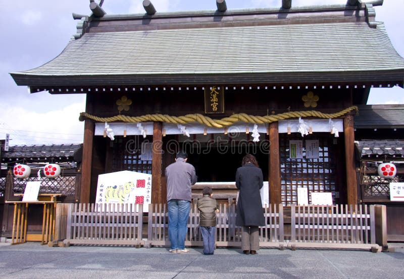 Japanese family in the temple shine. In the begining of a new year, Japanese people gathered to visit different shrines and pray for a good year. The event is called Hatsumonde. Japanese family in the temple shine. In the begining of a new year, Japanese people gathered to visit different shrines and pray for a good year. The event is called Hatsumonde.