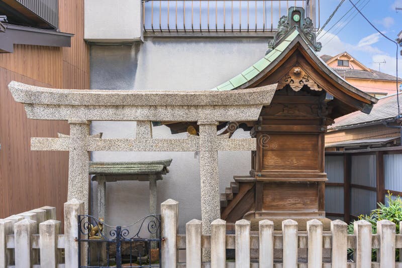 Tokyo, japan - march 10 2021: Japanese shintoist stone torii gate and small massha wooden altar dedicated to the Inari fox shinto kami god of rice in the neighborhood district of Sumida ward. Tokyo, japan - march 10 2021: Japanese shintoist stone torii gate and small massha wooden altar dedicated to the Inari fox shinto kami god of rice in the neighborhood district of Sumida ward