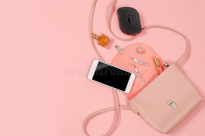 Top view of Women bag and lady stuff with copyspace on pink background. Top view of Women bag and lady stuff with copyspace on pink background