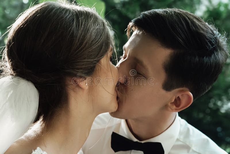 时髦的华美的愉快的亲吻在结婚宴会,情感快乐的片刻的新娘和新郎 免版税图库摄影 时髦的华美的愉快的亲吻在结婚宴会,情感快乐的片刻的新娘和新郎 免版税图库摄影