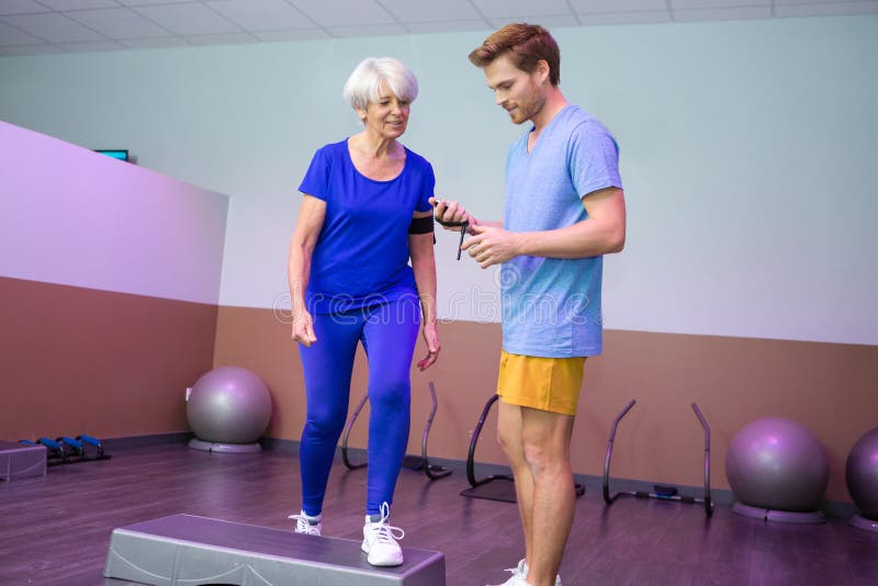 教练向一位老年妇女展示计时器 库存照片