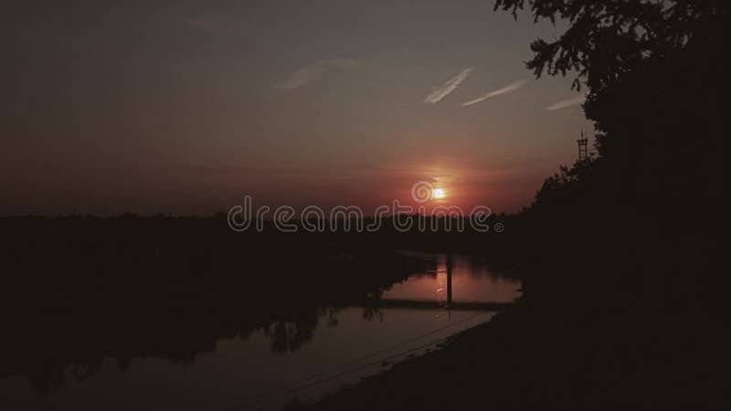 晚上日落的超级美丽的景色 太阳的一个美丽的圆盘在河的