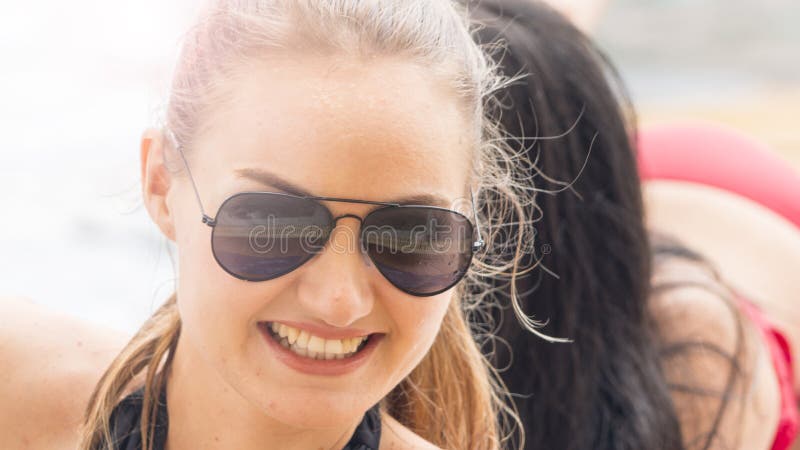 A woman with sunglasses in swimming wear get party pool with feeling happy. A woman with sunglasses in swimming wear get party pool with feeling happy