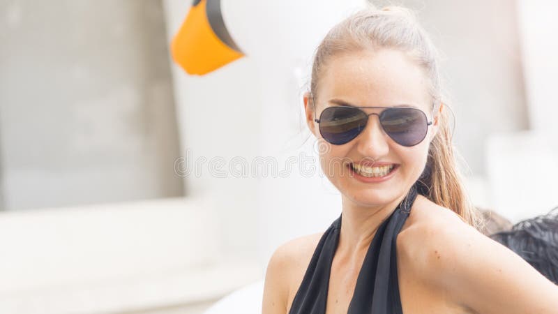 a woman with sunglasses in swimming wear get party pool with feeling happy. a woman with sunglasses in swimming wear get party pool with feeling happy