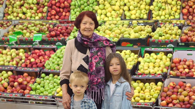 有孙的愉快的年长妇女在超级市场买果子 画象