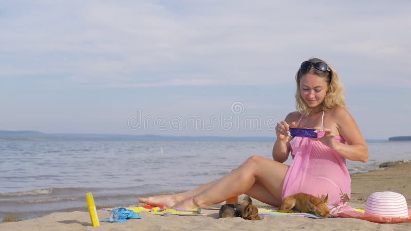 有手机的妇女在海滩