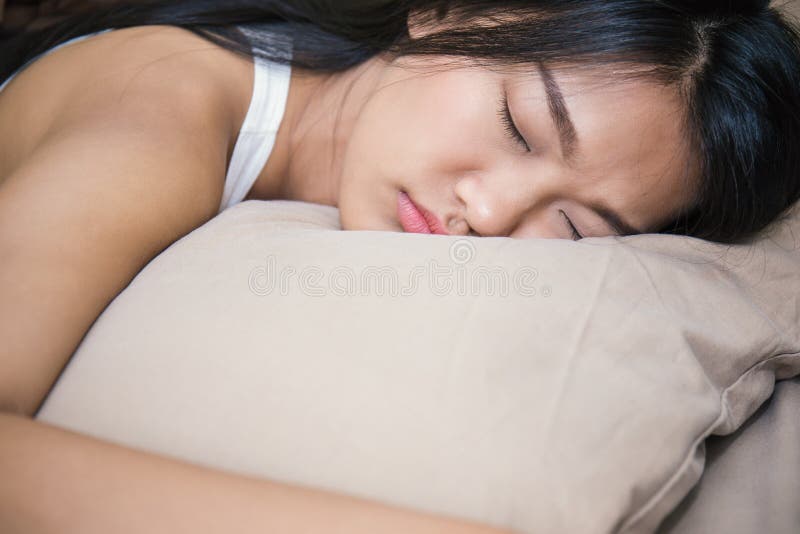有放置在床的有吸引力的微笑的美丽的年轻亚裔妇女 免版税库存照片 有放置在床的有吸引力的微笑的美丽的年轻亚裔妇女 免版税库存照片